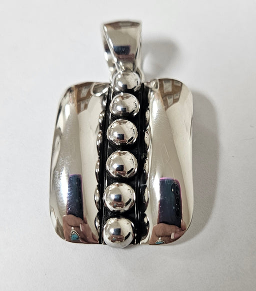 Silver pendant with spherical elements on a white background