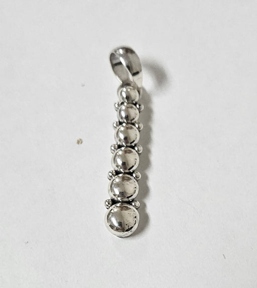 Silver pendant with five spherical beads on a white background