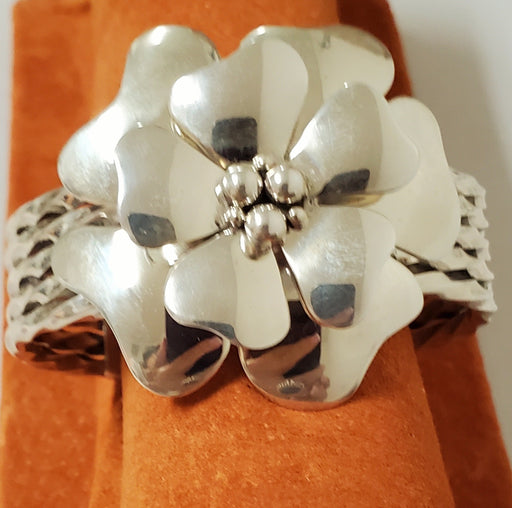 photo of Bracelet made of 4 piece twist silver band topped with Dogwood flower with small silver beads in center.