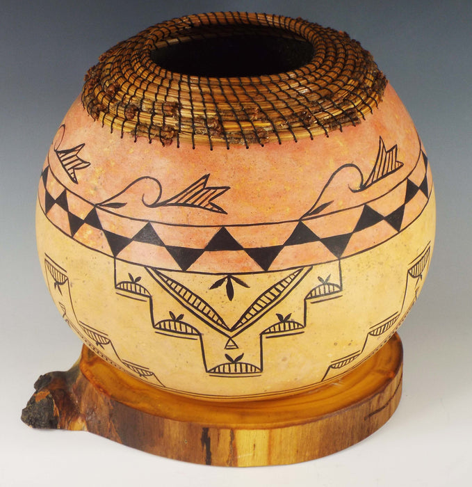 photo of gourd with pueblo style painting and pine needle weaving